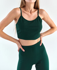 Poster - girl wears dark green leggings and dark green sleeveless top isolated. sport outfit for summer