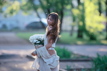 Wall Mural - girl holding a bouquet of flowers a walk in the park / romantic young beautiful cute model, love fee