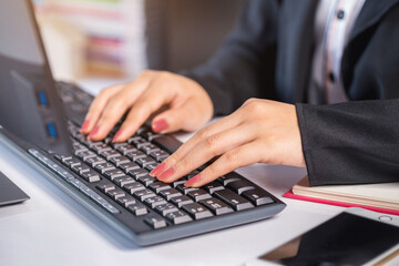 Close-up woman's hand typing on keyboard computer, businesswoman working in the office.