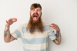 © Asier - Young caucasian ginger man with long beard isolated on white background screaming to the sky, looking up, frustrated.