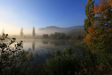 Wall Mural - Beautiful foggy morning in autumn in the mountains by the lake