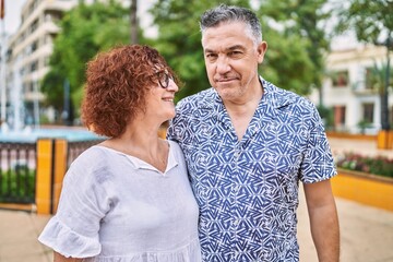 Middle age hispanic couple together outdoors on summer day