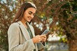 © Krakenimages.com - Young hispanic girl smiling happy using smartphone at the city.