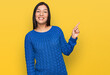 © Krakenimages.com - Young hispanic woman wearing casual clothes with a big smile on face, pointing with hand finger to the side looking at the camera.