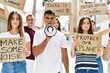 © Krakenimages.com - Group of young hispanic activists protesting holding banner and using megaphone at the city.