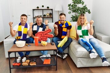 Poster - Group of middle age people wearing team scarf cheering football game screaming proud, celebrating victory and success very excited with raised arms