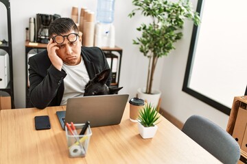 Canvas Print - Young latin businessman overworked working at the office.