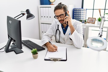 Wall Mural - Handsome hispanic man writing presciption on the phone at hospital clinic