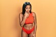 © Krakenimages.com - Young african american girl wearing bikini pointing to the eye watching you gesture, suspicious expression