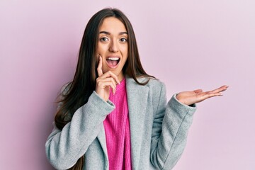 Sticker - Young hispanic girl presenting with open palms, holding something celebrating crazy and amazed for success with open eyes screaming excited.