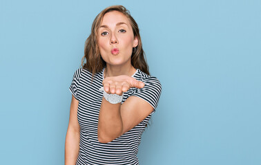 Poster - Young blonde woman wearing casual clothes looking at the camera blowing a kiss with hand on air being lovely and sexy. love expression.