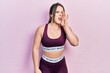 © Krakenimages.com - Young hispanic girl wearing sportswear shouting and screaming loud to side with hand on mouth. communication concept.