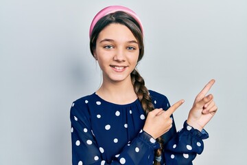 Sticker - Young brunette girl wearing elegant look smiling and looking at the camera pointing with two hands and fingers to the side.