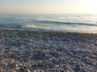 Summer, warmth, sun, pebble beach in Sochi Russia in soft morning sunlight.