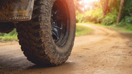 Wall Mural - The off-road vehicle's side On a gravel road, an off-road vehicle is parked. In the middle of a beautiful forest