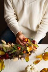 Wall Mural - Woman hands with diy floral autumn wreath with driad grass, plant and berry