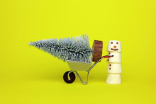 A Marshmallow Snowman Pushing A Wheelbarrow Containing An Artificial Christmas Tree.