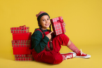 Wall Mural - Girl with Christmas presents on a yellow background 