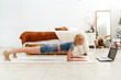 © undrey - Young woman doing the plank exercise at home