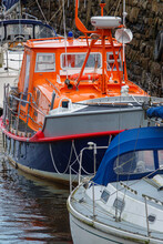 Boats With An Ex-service RNLI Lifeboat Moored Against The Harbour Wall In Penrhyn Docks, Bangor Wales UK