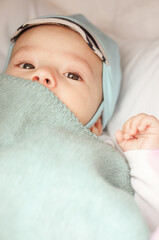 Canvas Print - Caucasian male infant lying under the blanket