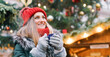 © Kzenon - Beautiful woman drinking mulled wine on Christmas market in front of decorated three