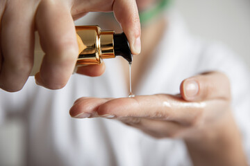 Canvas Print - A woman presses on the dispenser of beauty care products, blurred background.