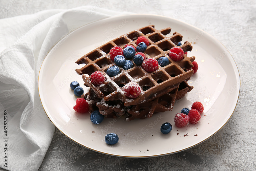 Plate of delicious Chocolate Belgian Waffles with berries on light background
