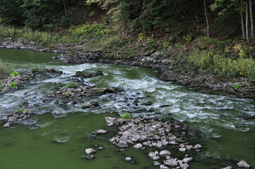 Sticker - Cascade of water flowa through rocks in the river