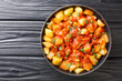 Patatas Bravas recipe fried potatoes with bravas sauce close up in the plate on the table. Horizontal top view from above