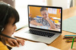 © vectorfusionart - Asian girl using laptop for video call, with elementary school pupil on screen