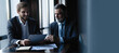 © opolja - Senior and junior businessman discuss something during their meeting, office background.