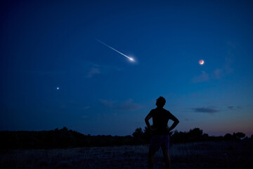 Wall Mural - silhouette of a man enjoying countryside under the starry skies.