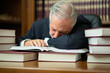 © Minerva Studio - Sleepy businessman lawyer surrounded by many books