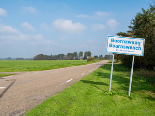 Wall Mural - Bilingual place name sign in Frisian and Dutch of Boornzwaag by polder road, Friesland, Netherlands