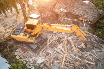 Wall Mural - Excavator breaks old house, many dust in air. Building demolition and deconstruction, aerial view.