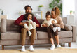 © JenkoAtaman - Joyful african american family parents and two little kids having fun together at home