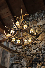 Sticker - Deer antler chandelier in front of a rock wall at a lodge