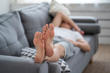 Tired Man Resting After Work At Home, Male Feet, Body Care Concept