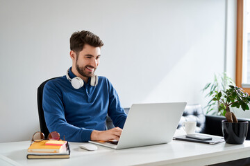 Smiling young man working on laptop