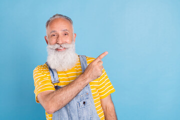 Wall Mural - Photo of funny old grey man point empty space wear yellow t-shirt overall isolated on blue color background