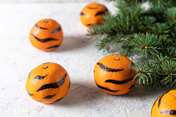 Wall Mural - Tangerines with painted stripes. The concept for the tiger new year with a Christmas tree. Tiger mandarines