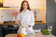 © dikushin - Portrait of smiling attractive young woman making healthy vegetable detox smoothie juice in blender standing posing in kitchen room with light modern interior. Concept of healthy eating and lifestyle.
