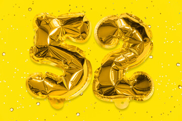 The number of the balloon made of golden foil, the number fifty-two on a yellow background with sequins. Birthday greeting card with inscription 52. Numerical digit, Celebration event, template.