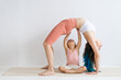© Вадим Каштанов - Little daughter helps mom practice yoga. Happy and healthy family.
