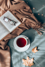 Hot Cup Of Herbal Tea With Book In Grey Bed. Cozy Autumn.