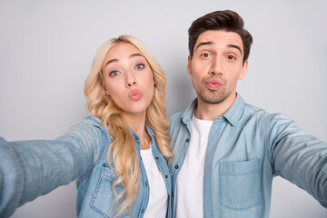 Sticker - Photo of pretty charming young couple dressed jeans shirts tacking selfie sending you kiss isolated grey color background