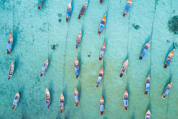 Wall Mural - Stunning summer landscape. Aerial view of fishing long tail boat group in turquoise Andaman sea at Koh Lipe or Lipe island, Satun, Southern Thailand. Shot from drone