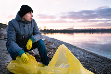 Man cleaning polluted sea shore from plastic garbage