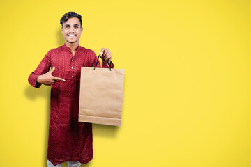 Sticker - Indian man in ethnic wear with shopping bags, isolated over yellow background